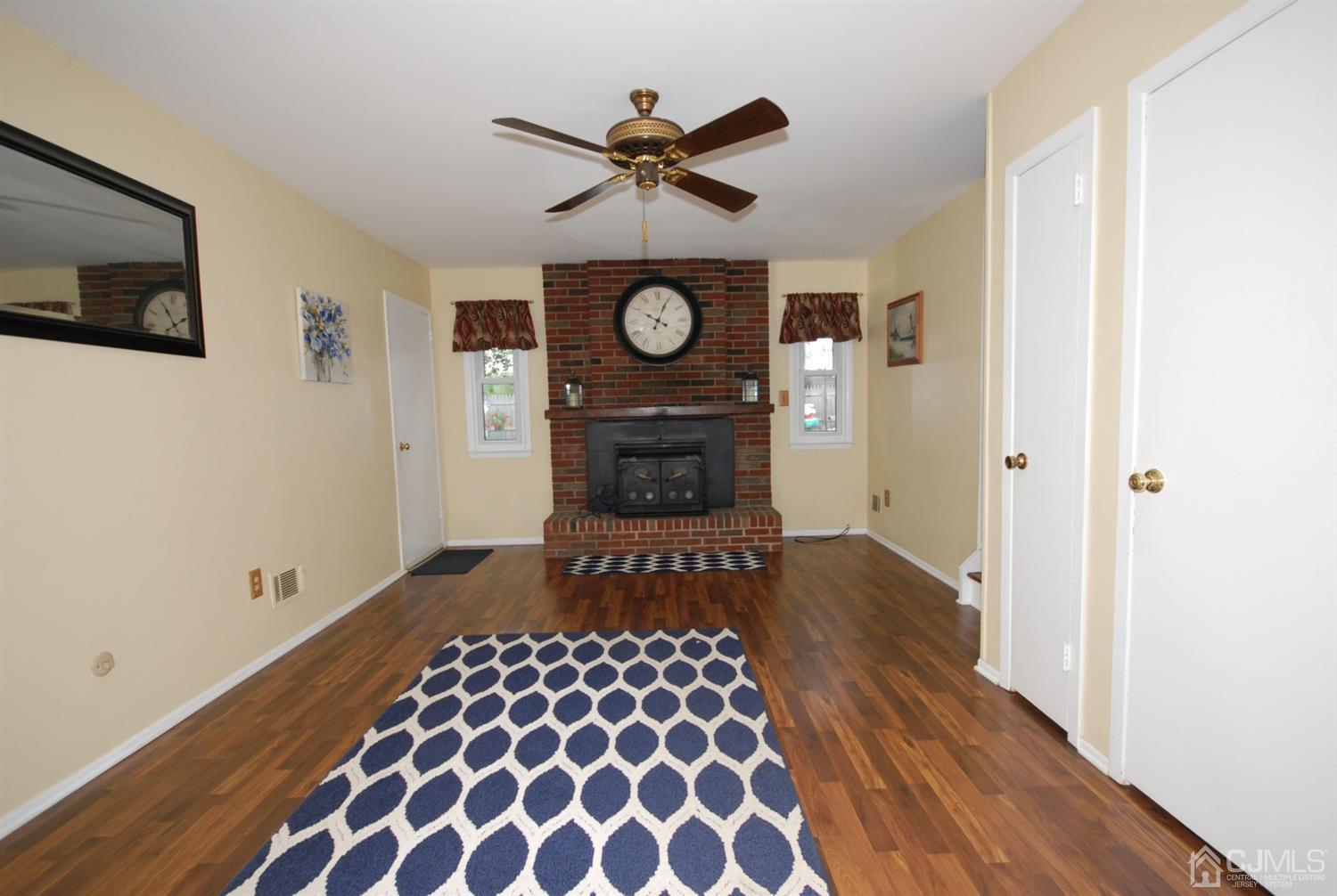 61 Greenbrook Road Middlesex, NJ 08846 - Photo 11 of 29 a view of a hallway with wooden floor a flat screen tv and a clock