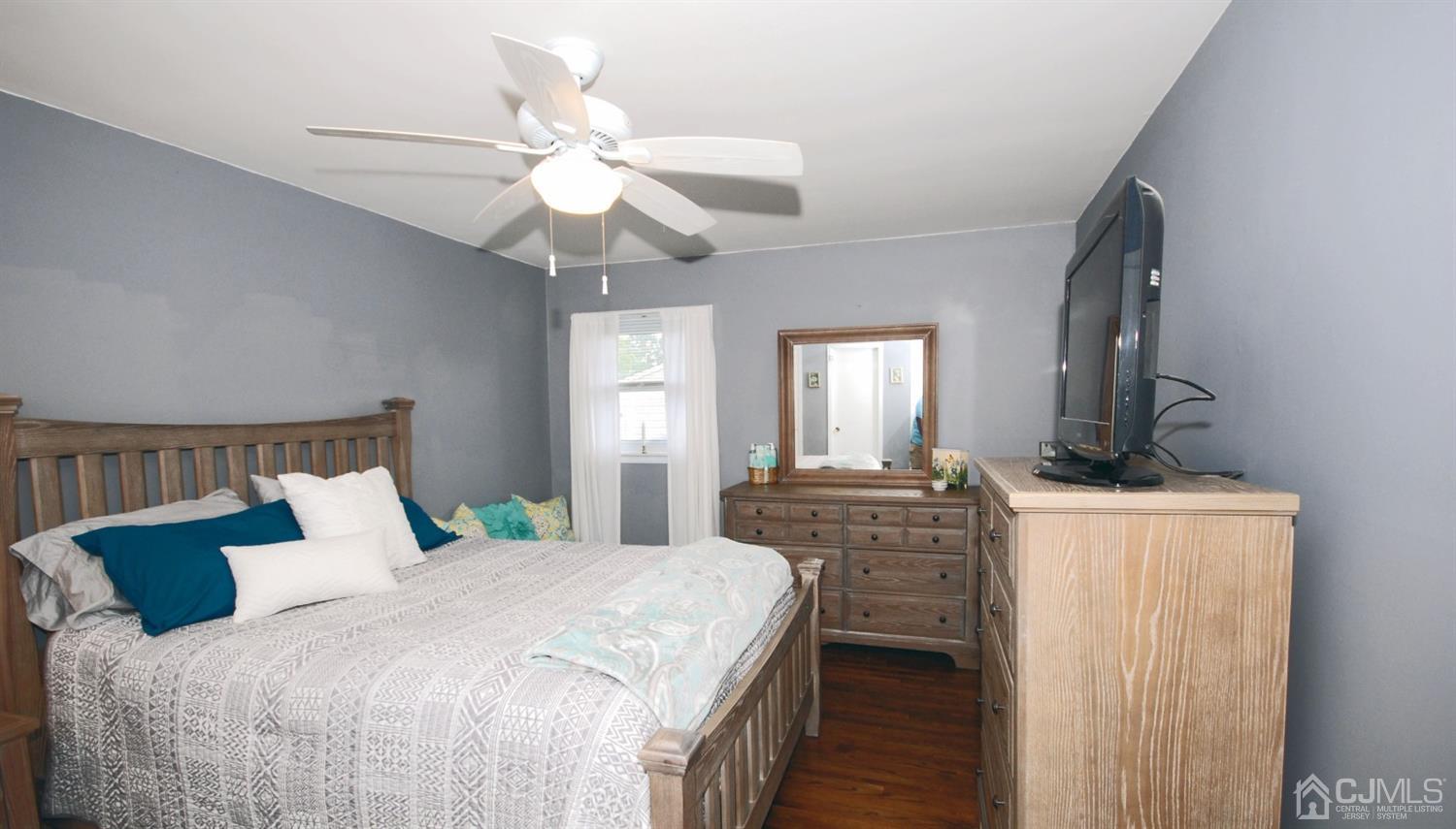 61 Greenbrook Road Middlesex, NJ 08846 - Photo 13 of 29 a bedroom with a bed a dresser and potted plants with the wooden floor