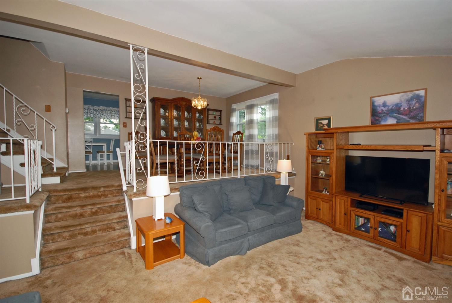 61 Greenbrook Road Middlesex, NJ 08846 - Photo 19 of 29 a living room with furniture a flat screen tv and a fireplace
