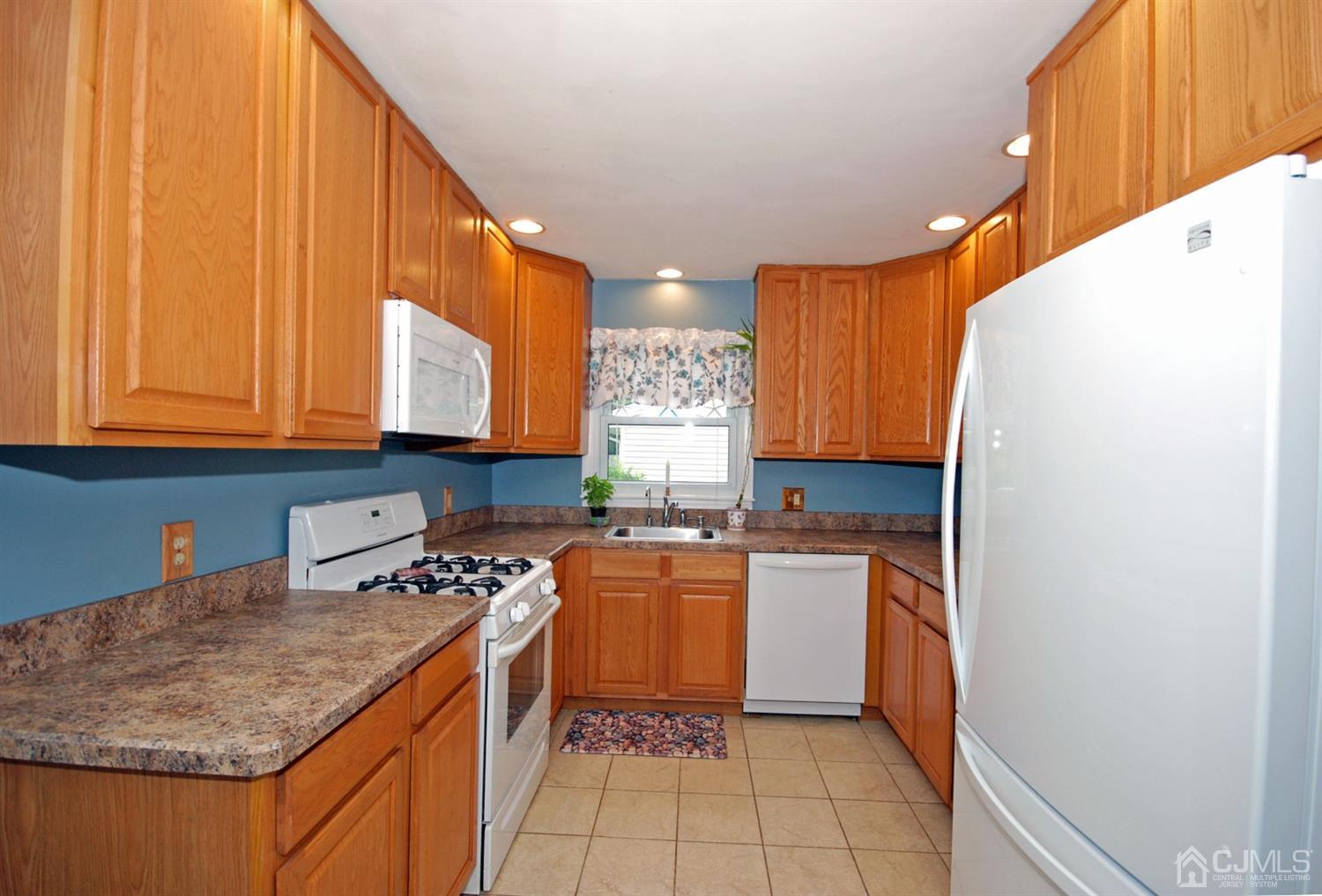 61 Greenbrook Road Middlesex, NJ 08846 - Photo 9 of 29 a kitchen with a sink a stove top oven and cabinets