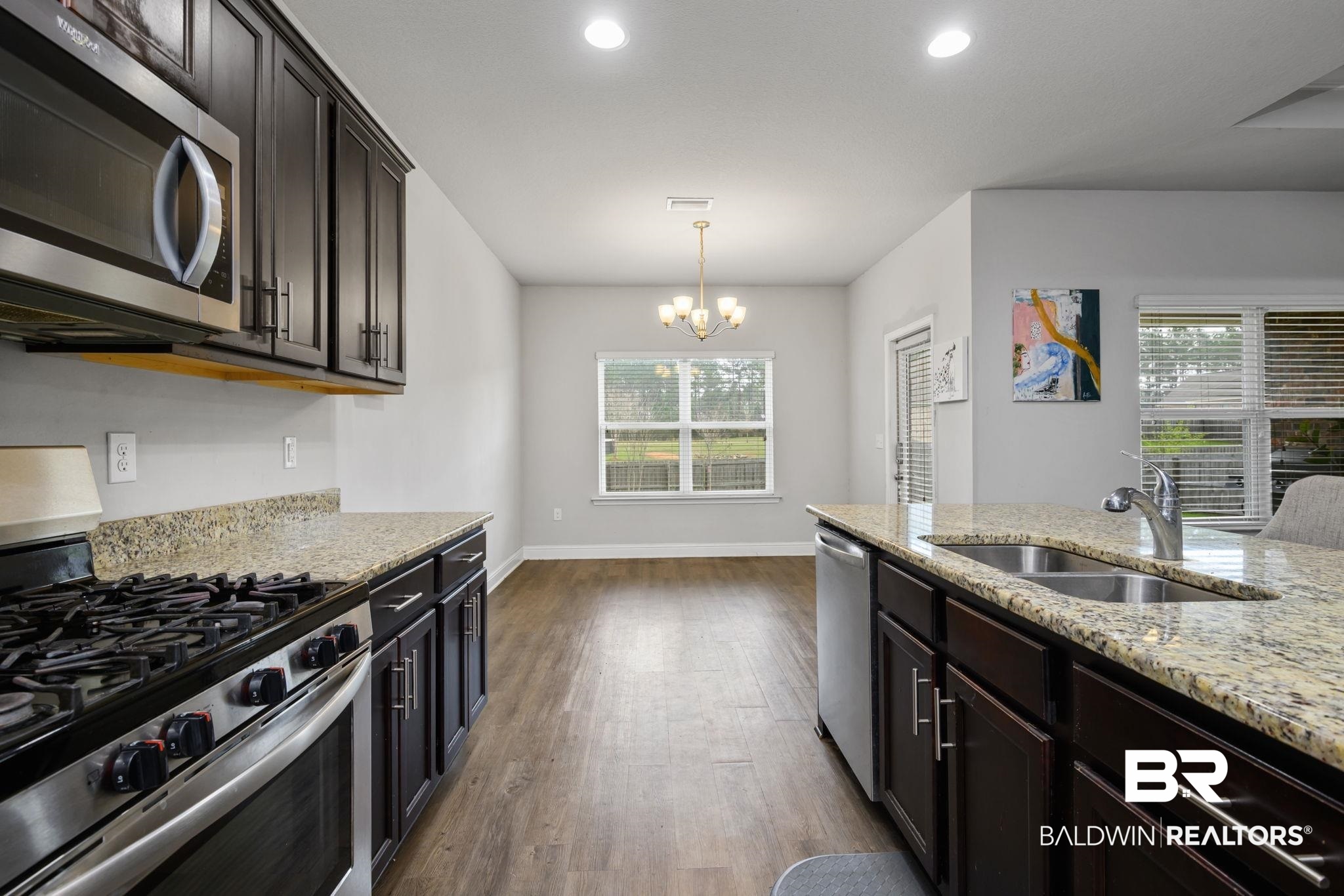 12693 Waxwing Avenue Daphne, AL 36527 - Photo 19 of 43 Kitchen with stainless steel appliances, light stone countertops, and dark wood finish cabinets