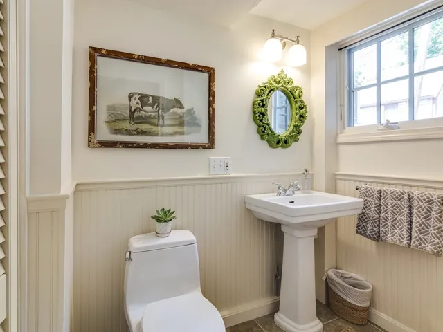 a bathroom with a toilet a sink and mirror