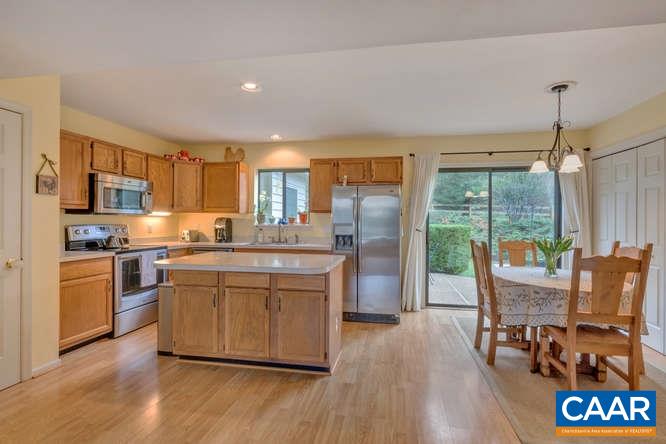 1134 Amber Ridge Road Charlottesville, VA 22901 - Photo 7 of 34 a kitchen with stainless steel appliances granite countertop a refrigerator a stove top oven a sink dishwasher and wooden cabinets with wooden floor