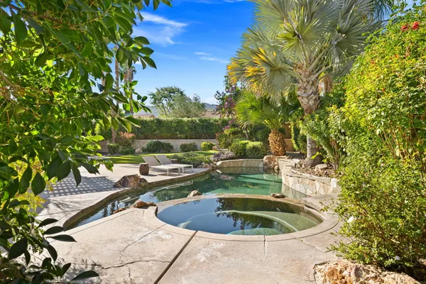 a kitchen with stainless steel appliances kitchen island granite countertop a stove a white cabinets and couches with wooden floor