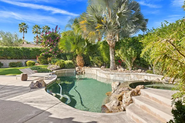 a living room with furniture ceiling fan and a large window