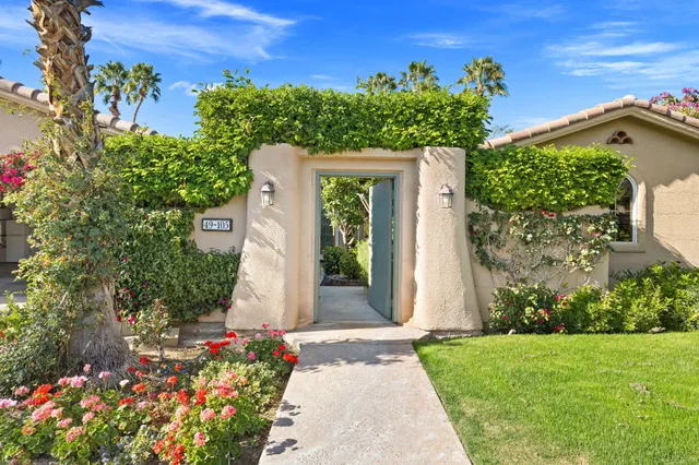 a kitchen with stainless steel appliances kitchen island granite countertop a stove a white cabinets and couches with wooden floor