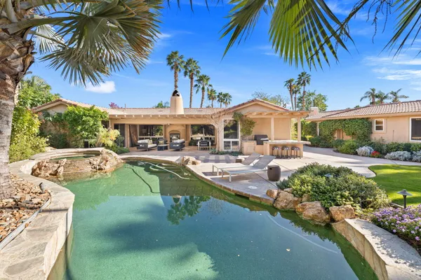 a view of a house with a yard patio and fire pit