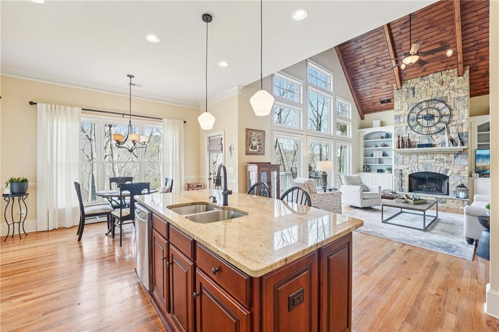 29 Red Trillium Ridge Big Canoe, GA 30143 - Photo 19 of 76 a kitchen with stainless steel appliances granite countertop a stove oven a dining table and chairs with wooden floor