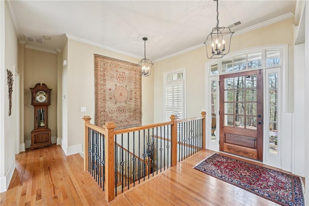 29 Red Trillium Ridge Big Canoe, GA 30143 - Photo 4 of 76 a view of a hallway to a livingroom with wooden floor and windows