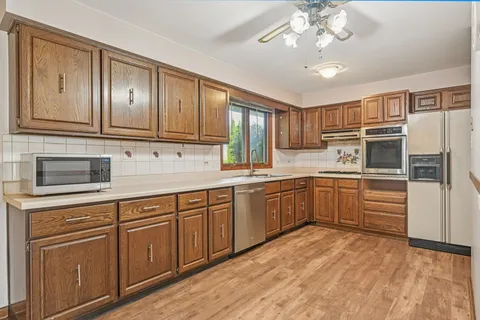 a kitchen with stainless steel appliances granite countertop a refrigerator and a sink