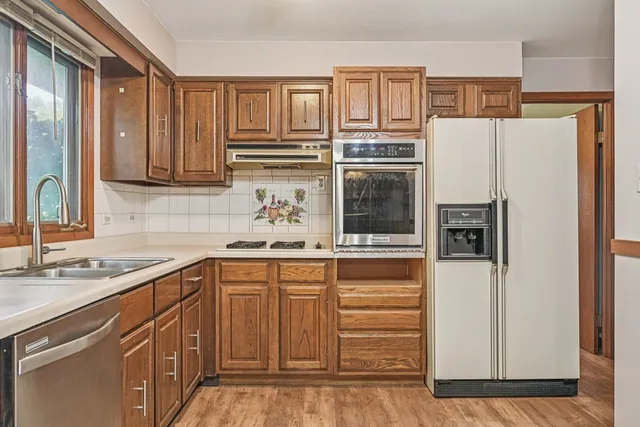 a kitchen with stainless steel appliances granite countertop a sink stove and cabinets