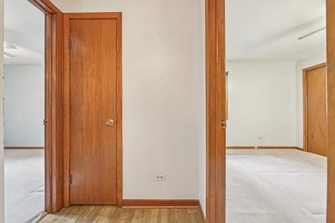 an empty room that has a window and a chandelier fan
