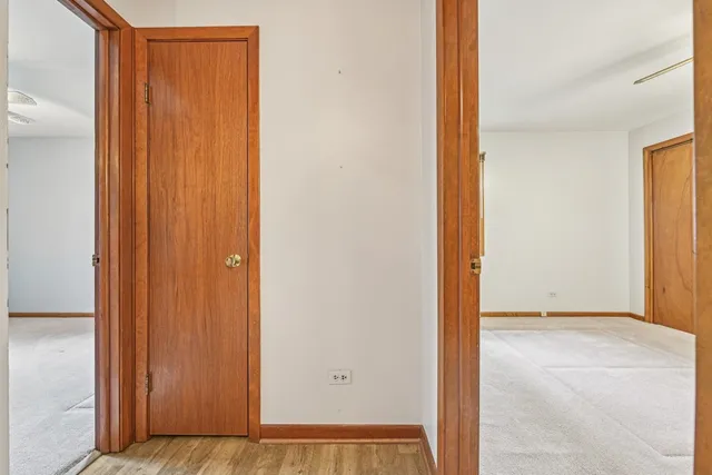an empty room that has a window and a chandelier fan