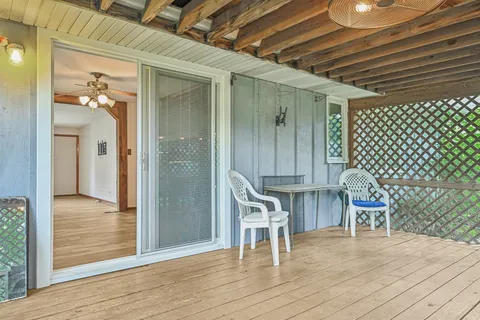 a view of a house with a backyard and a tree