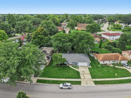 an aerial view of residential houses with outdoor space and trees