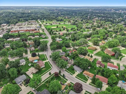 an aerial view of residential houses with outdoor space and trees