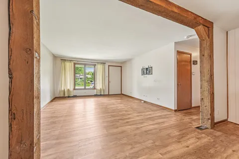 a view of an empty room with window and fire place