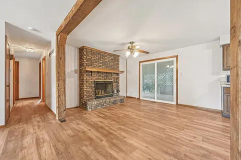 a view of an empty room with a fireplace and a window