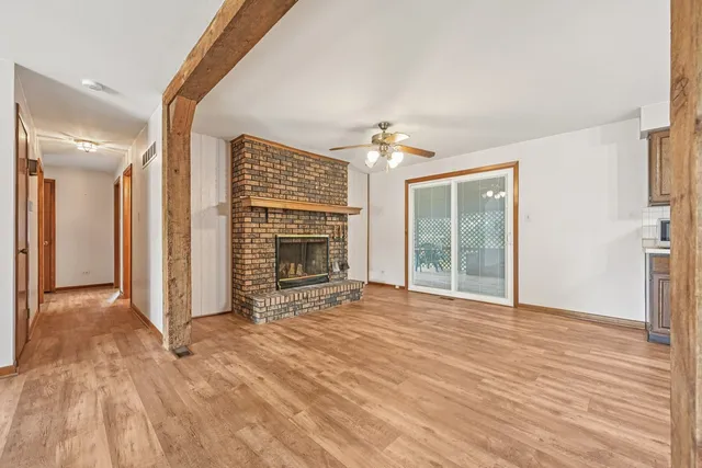 a view of an empty room with a fireplace and a window
