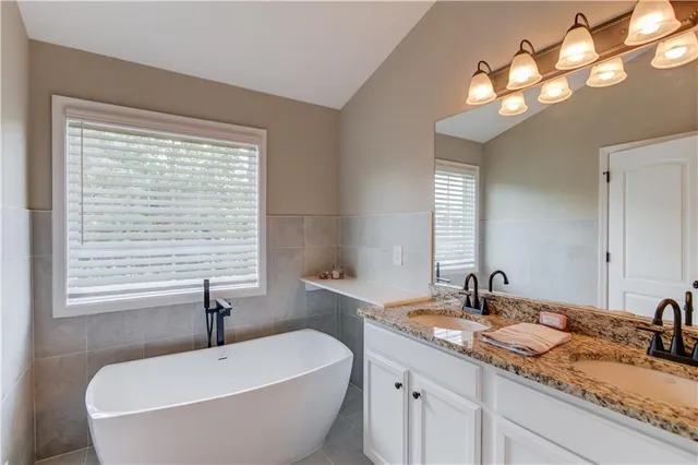 a bathroom with a granite countertop sink and a large mirror