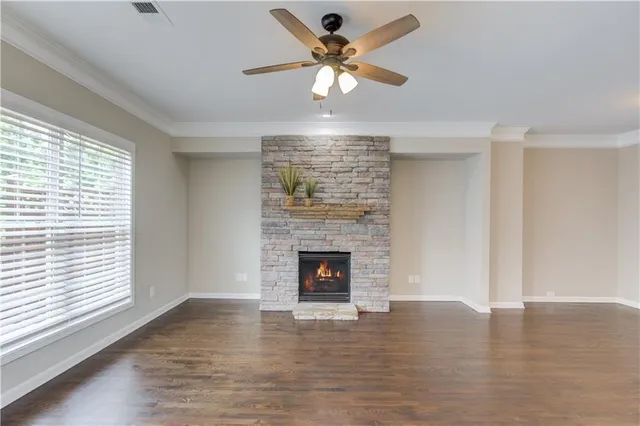 a view of a livingroom with a fireplace a ceiling fan and window