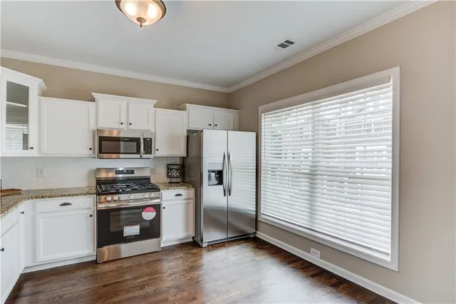 a kitchen with stainless steel appliances a refrigerator sink and microwave