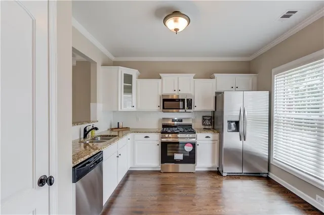 a kitchen with stainless steel appliances a refrigerator sink and cabinets