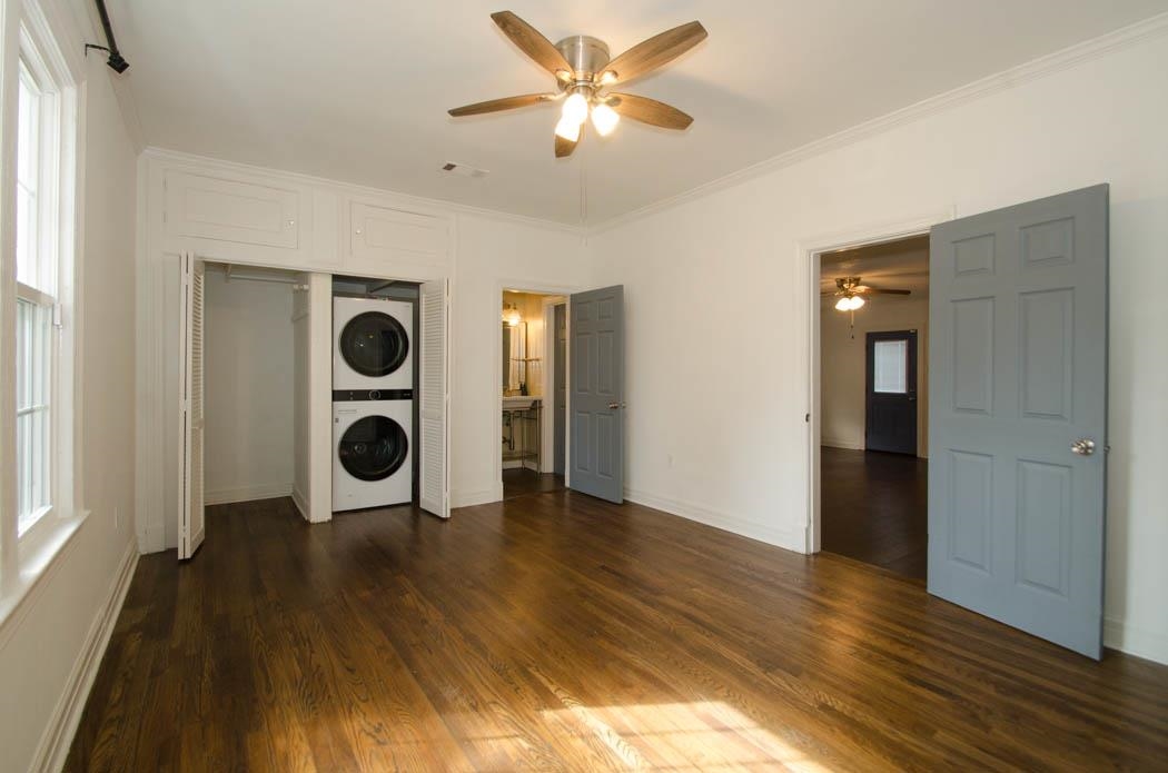 4572 Princeton Road Memphis, TN 38117 - Photo 12 of 24 Unfurnished bedroom with stacked washer and clothes dryer, dark wood-type flooring, crown molding, a closet, and a ceiling fan