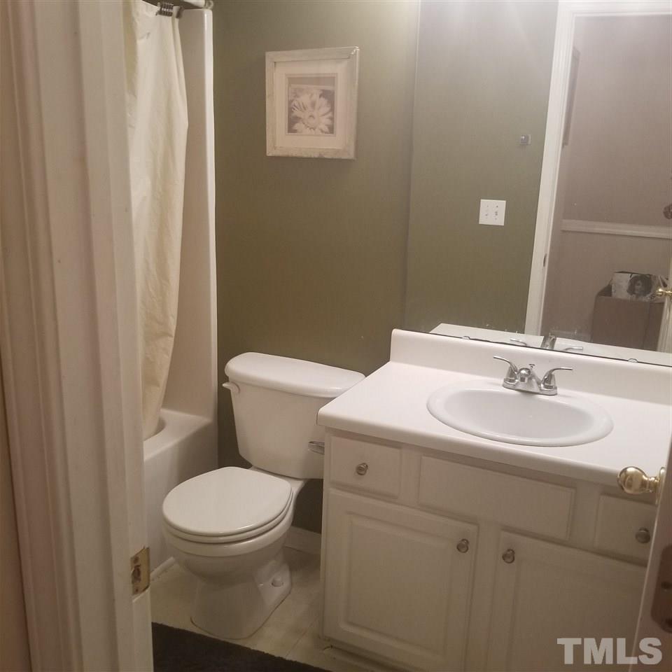5330 Glen Canyon Road Raleigh, NC 27616 - Photo 13 of 15 a bathroom with a toilet a sink and a mirror