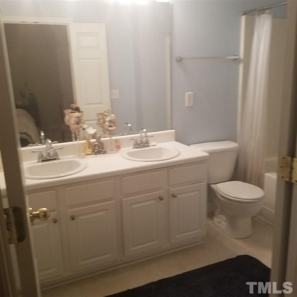 5330 Glen Canyon Road Raleigh, NC 27616 - Photo 10 of 15 a bathroom with a toilet a sink and mirror