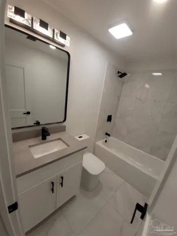 a bathroom with a double vanity sink toilet mirror and bathtub
