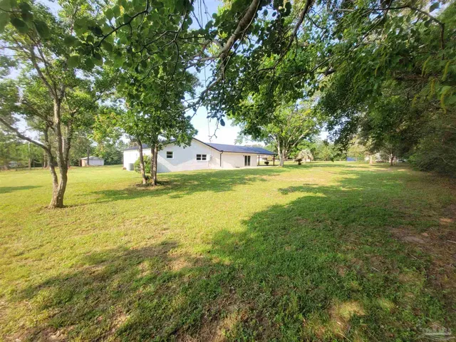 a view of yard with swimming pool and trees