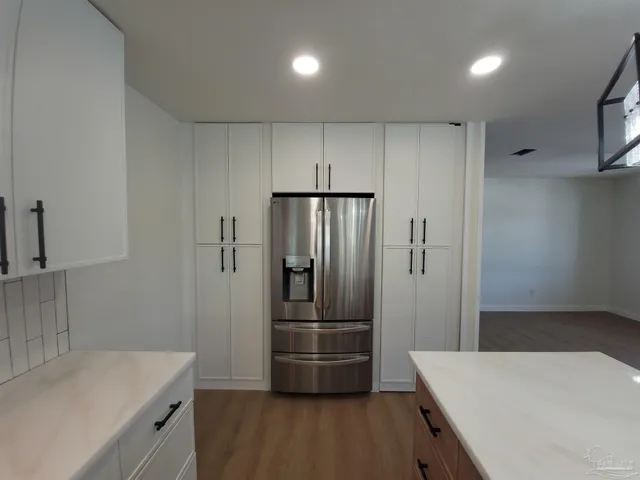a kitchen with granite countertop a refrigerator and a sink