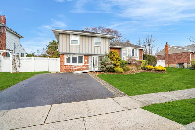 a front view of a house with a yard and trees