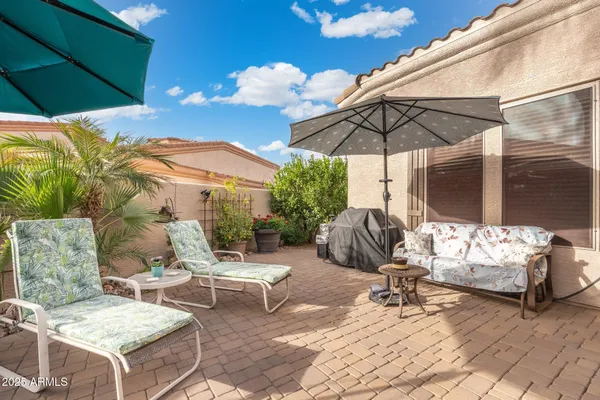 a view of a patio with a table and chairs under an umbrella