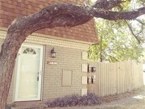 a front view of a house with a tree