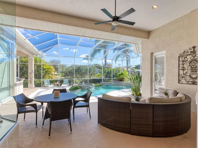 a living room with furniture a flat screen tv and a floor to ceiling window
