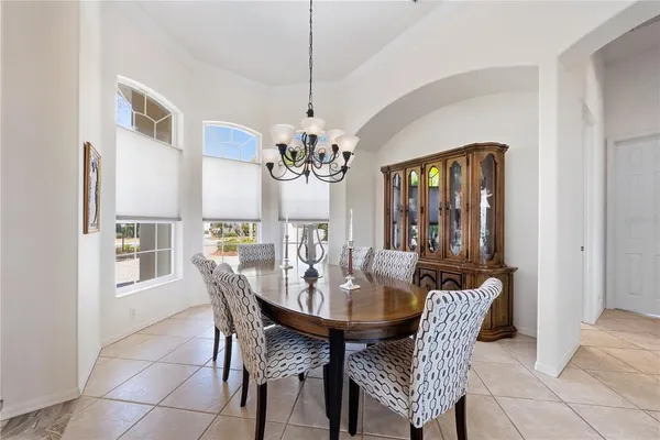 a view of a dining room with furniture a chandelier and large window