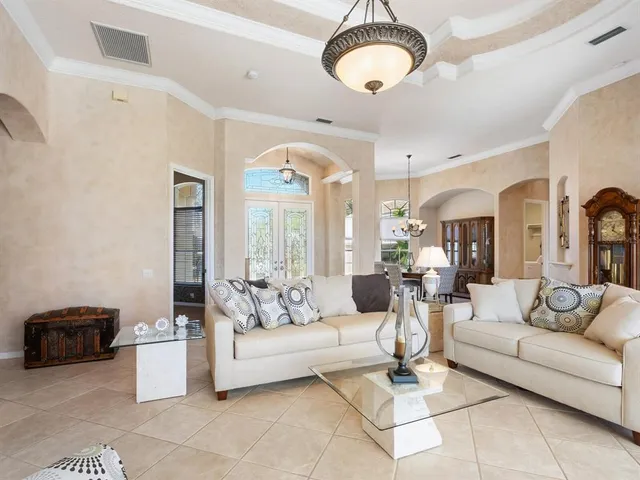 a living room with furniture a chandelier and a dining table