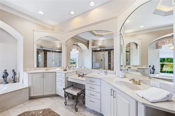 a large bathroom with a large tub sink and mirror