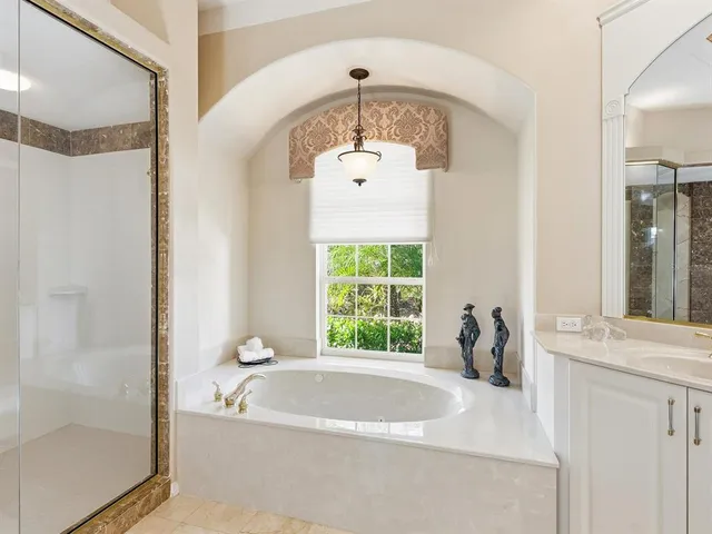 a large bathroom with a large tub sink and mirror