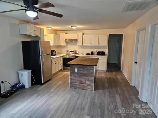a kitchen with a refrigerator and a stove top oven