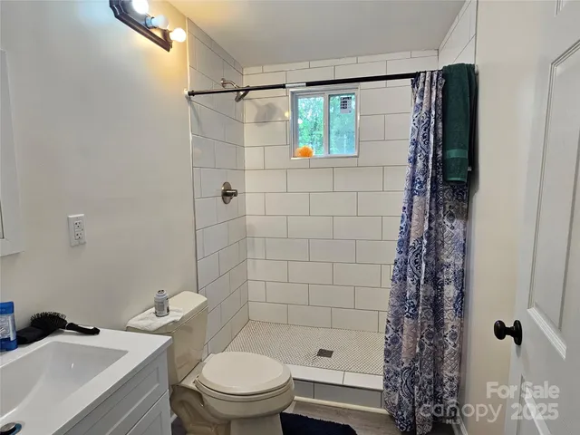 a bathroom with a shower a toilet and a sink