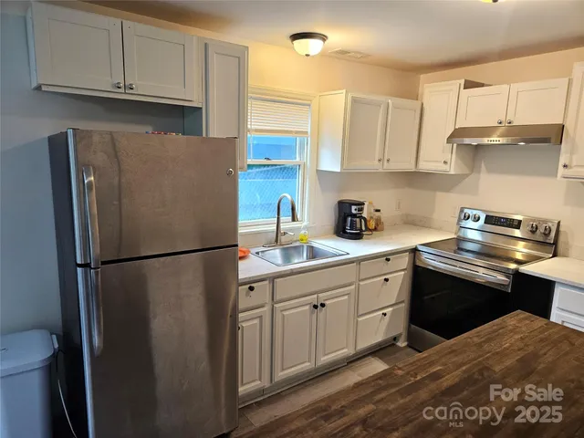 a kitchen with stainless steel appliances a refrigerator sink and cabinets