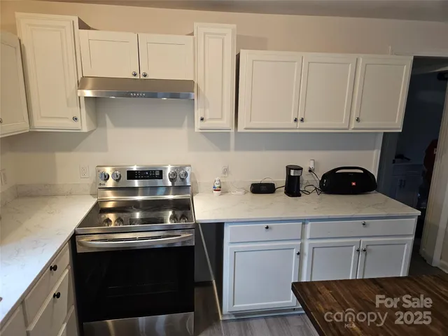a kitchen with white cabinets and appliances