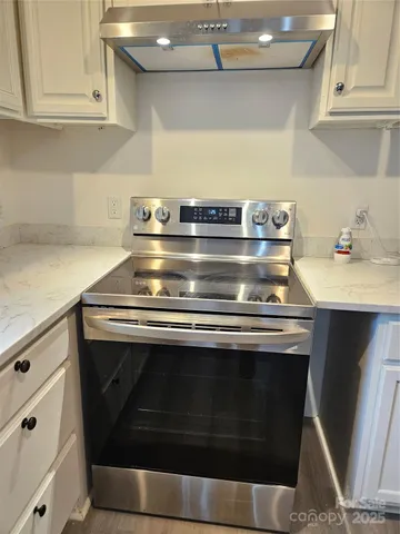 a stove top oven sitting inside of a kitchen