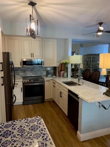 a kitchen with stainless steel appliances granite countertop a stove a sink and a refrigerator