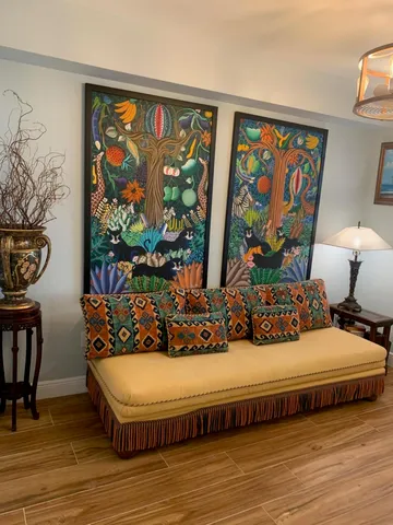 a living room with furniture and wall paintings