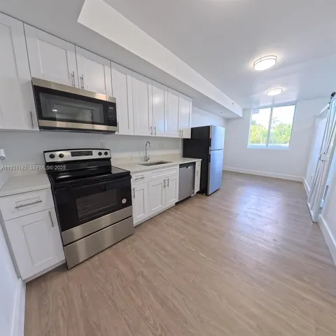 a kitchen with stainless steel appliances a stove a microwave and sink
