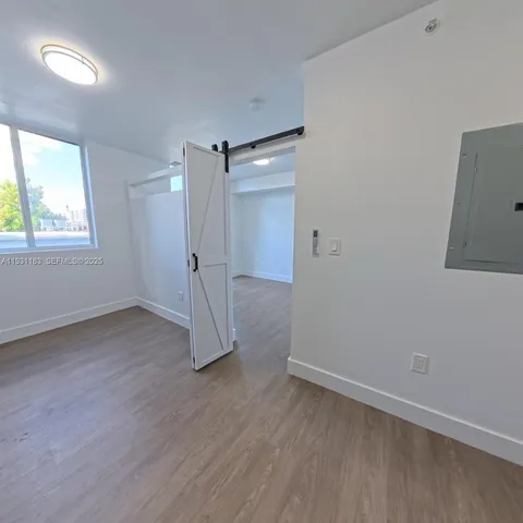an empty room with a wooden floor and a window
